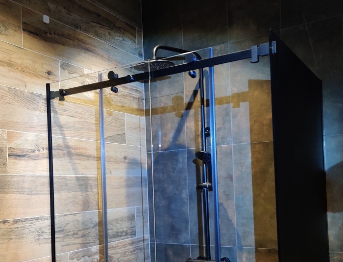 Угловая душевая с раздвижной дверью из стекла